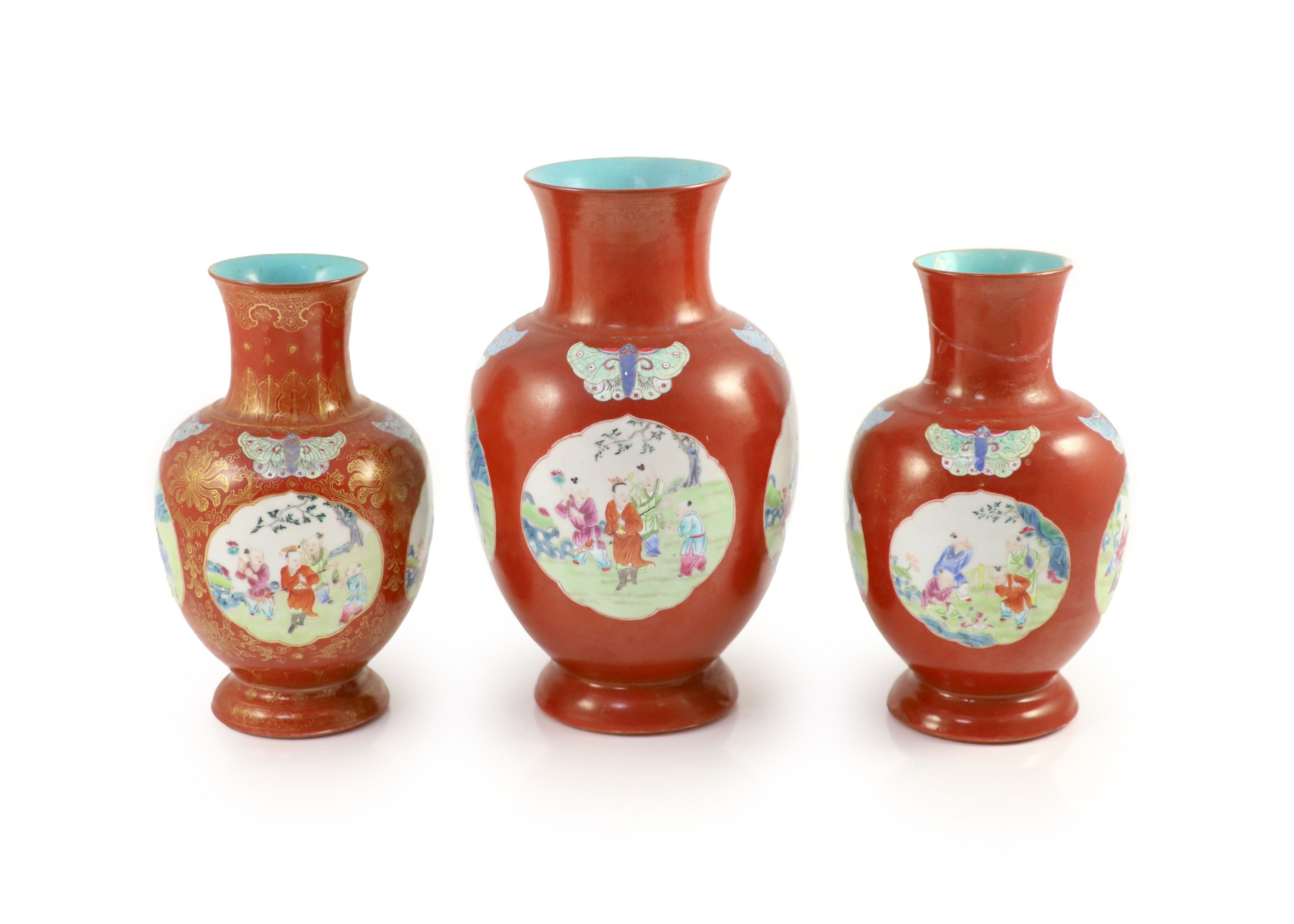 A set of three Chinese coral ground ‘boys’ vases, Jiaqing period (1796-1820), 19.5 and 23.5cm high